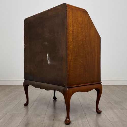 fig 6. An Edwardian figured walnut writing bureau featuring a slant front above three drawers and carved cabriole legs.