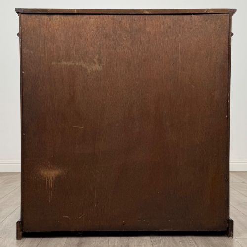 fig 5. An early twentieth-century open mahogany bookcase featuring three wide horizontal shelves, a heavy moulded cornice, and a solid rectangular plinth base.