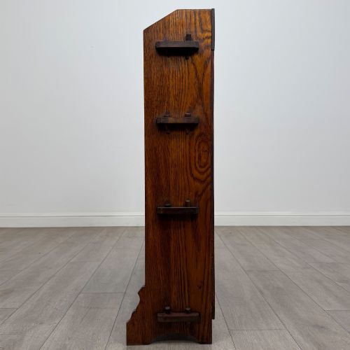 fig 3. An early twentieth-century open golden oak bookcase featuring four wide wooden shelves and shaped side profile base.