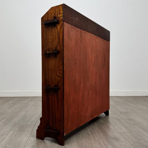fig 4. An early twentieth-century open golden oak bookcase featuring four wide wooden shelves and shaped side profile base.