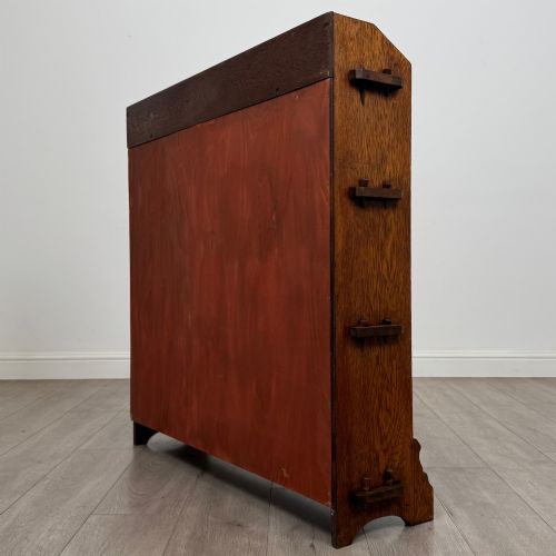 fig 6. An early twentieth-century open golden oak bookcase featuring four wide wooden shelves and shaped side profile base.