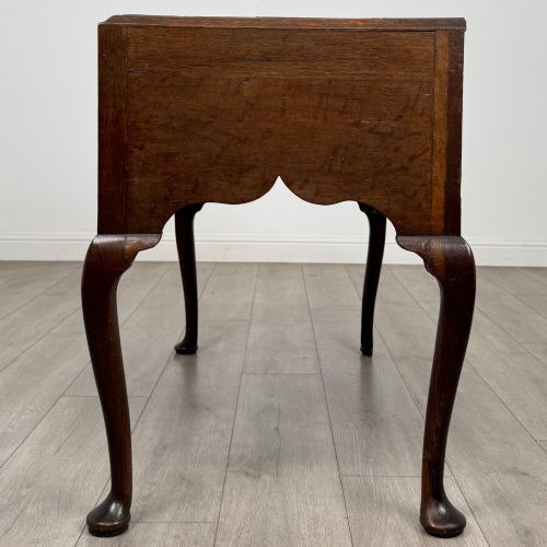 fig 2. An 18th-century Georgian oak side table featuring three drawers with brass drop handles, an arched apron, and cabriole legs.
