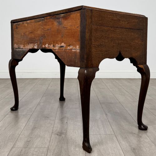 fig 5. An 18th-century Georgian oak side table featuring three drawers with brass drop handles, an arched apron, and cabriole legs.