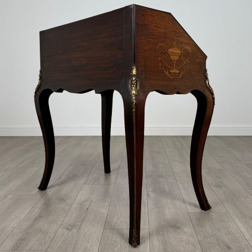 fig 6. A 19th-century French rosewood bureau de dame with floral marquetry inlay on the hinged top and apron, raised on cabriole legs with gilt-bronze ormolu mounts.