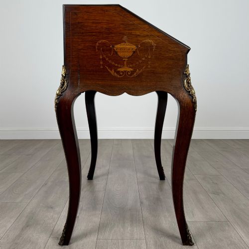fig 7. A 19th-century French rosewood bureau de dame with floral marquetry inlay on the hinged top and apron, raised on cabriole legs with gilt-bronze ormolu mounts.