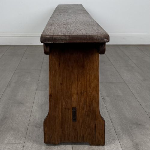 fig 6. A long 19th-century Georgian oak tavern bench featuring a smooth plank seat supported by three sturdy slab legs and a full-length lower stretcher.