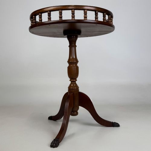 fig 1. A dark brown beech side table featuring a spindle gallery rim around the circular top, a turned column support, and a tripod base with claw feet.