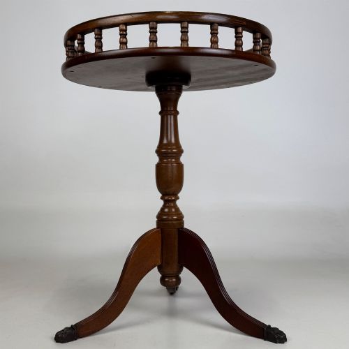 fig 2. A dark brown beech side table featuring a spindle gallery rim around the circular top, a turned column support, and a tripod base with claw feet.
