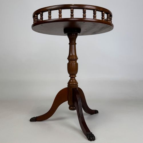 fig 3. A dark brown beech side table featuring a spindle gallery rim around the circular top, a turned column support, and a tripod base with claw feet.