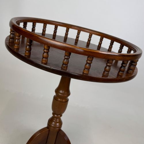 fig 5. A dark brown beech side table featuring a spindle gallery rim around the circular top, a turned column support, and a tripod base with claw feet.