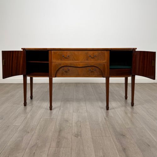 fig 1. A 19th-century mahogany bow-front sideboard with central drawers, side cupboards, and tapered square legs.