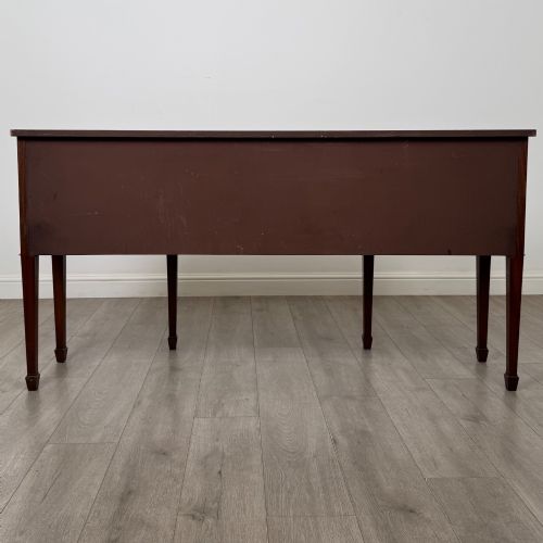 fig 5. A 19th-century mahogany bow-front sideboard with central drawers, side cupboards, and tapered square legs.