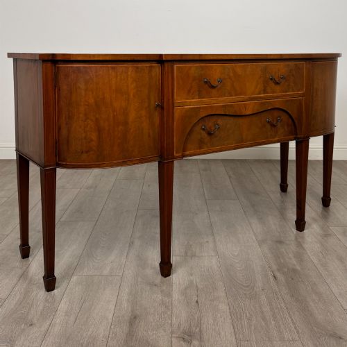 fig 8. A 19th-century mahogany bow-front sideboard with central drawers, side cupboards, and tapered square legs.