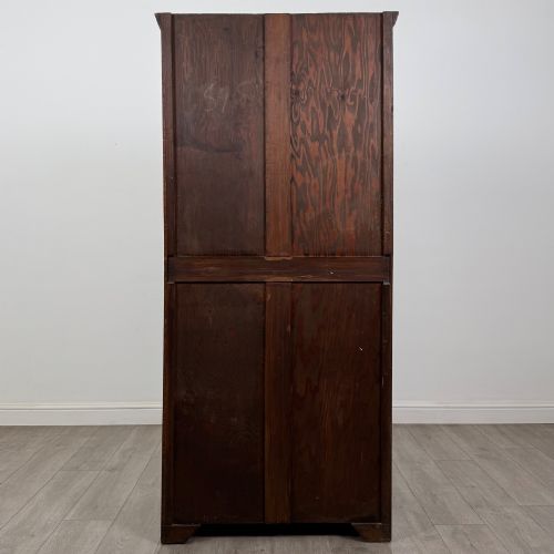 fig 5. A tall single-door dark oak Edwardian wardrobe featuring a carved upper linenfold panel and decorative iron hinges.