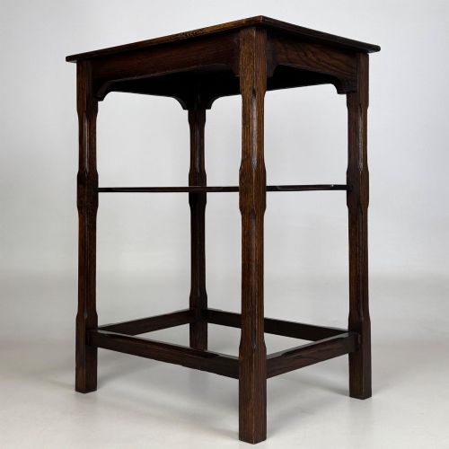 fig 1. An Edwardian dark oak side table with a flat square top, lower tier shelf, shaped aprons, and straight square legs.
