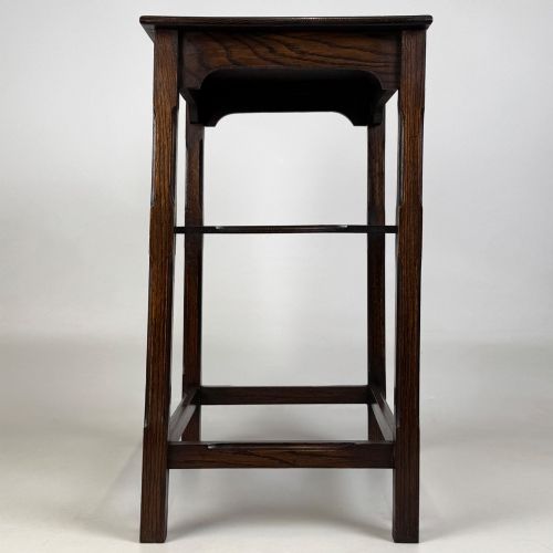 fig 2. An Edwardian dark oak side table with a flat square top, lower tier shelf, shaped aprons, and straight square legs.