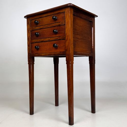 fig 1. A Victorian pitch pine cabinet with three drawers and black wooden knobs set on elevated tapered square legs.