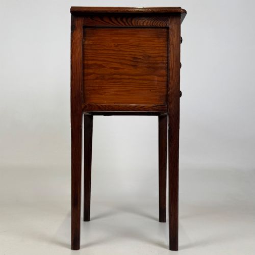 fig 6. A Victorian pitch pine cabinet with three drawers and black wooden knobs set on elevated tapered square legs.