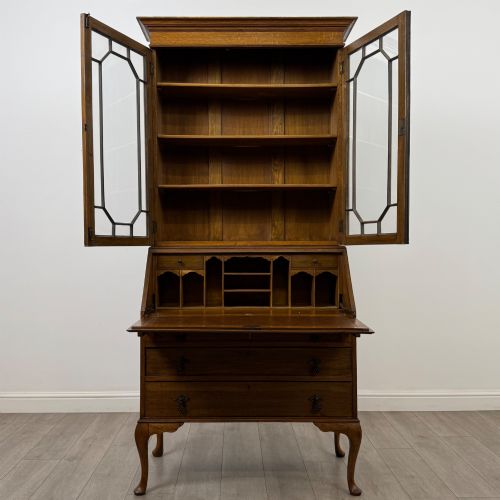 fig 2. An Edwardian oak bureau bookcase with a two-door upper glazed display cabinet, a sloping drop-front desk, three wide drawers, and cabriole legs.