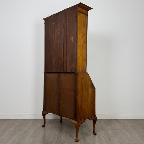 fig 7. An Edwardian oak bureau bookcase with a two-door upper glazed display cabinet, a sloping drop-front desk, three wide drawers, and cabriole legs.