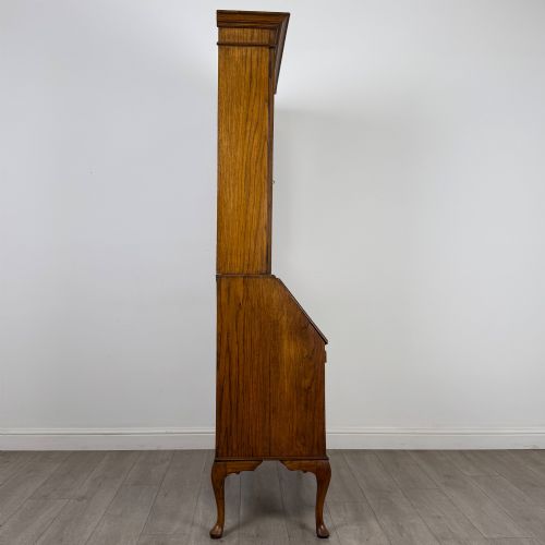 fig 8. An Edwardian oak bureau bookcase with a two-door upper glazed display cabinet, a sloping drop-front desk, three wide drawers, and cabriole legs.