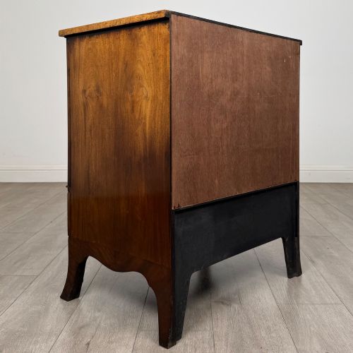 fig 4. A 20th-century mahogany serpentine cupboard featuring flame mahogany oval door panels, chevron veneering, a lower drawer with brass ring handles, and splayed bracket feet.
