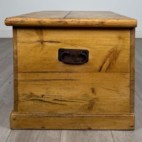 fig 2. A 19th-century Victorian pine blanket box featuring a flat hinged lid, visible wood grain, central keyhole, and solid plinth base.