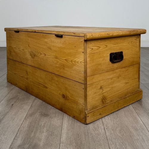 fig 5. A 19th-century Victorian pine blanket box featuring a flat hinged lid, visible wood grain, central keyhole, and solid plinth base.