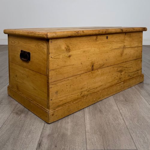 fig 7. A 19th-century Victorian pine blanket box featuring a flat hinged lid, visible wood grain, central keyhole, and solid plinth base.