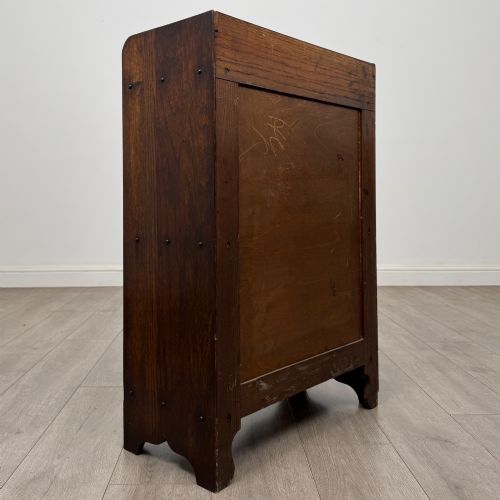 fig 4. An early 20th-century dark oak display cabinet featuring twin glazed doors, an interior shelf, and a gallery top.