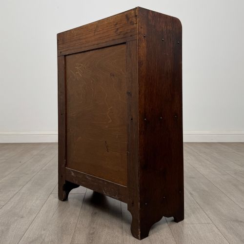 fig 6. An early 20th-century dark oak display cabinet featuring twin glazed doors, an interior shelf, and a gallery top.