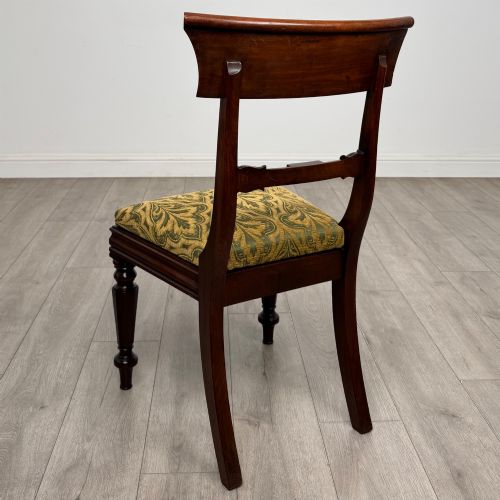 fig 2. A set of six 19th-century William IV mahogany dining chairs featuring turned front legs, curved back rails, and green patterned fabric seats.
