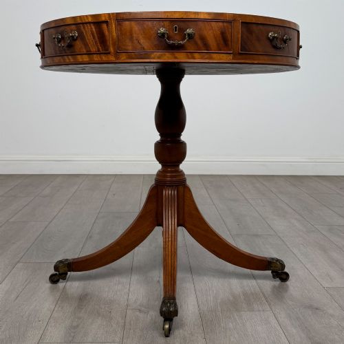 fig 1. A small Regency style circular mahogany drum table featuring frieze drawers with brass handles, supported by a central turned pedestal and reeded splayed legs on brass castors.