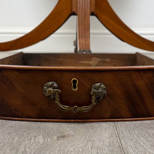 fig 7. A small Regency style circular mahogany drum table featuring frieze drawers with brass handles, supported by a central turned pedestal and reeded splayed legs on brass castors.
