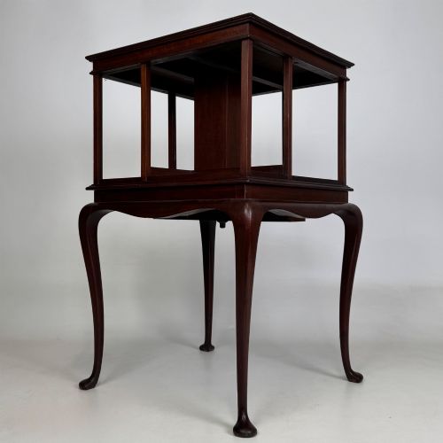 fig 1. A dark mahogany revolving bookcase featuring a two-tier rotating upper section supported by slender cabriole legs ending in pad feet.