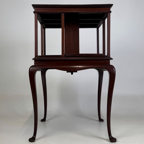 fig 2. A dark mahogany revolving bookcase featuring a two-tier rotating upper section supported by slender cabriole legs ending in pad feet.
