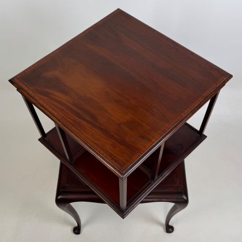 fig 7. A dark mahogany revolving bookcase featuring a two-tier rotating upper section supported by slender cabriole legs ending in pad feet.