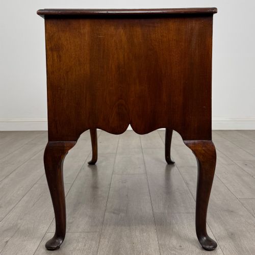 fig 2. A 19th-century Victorian writing table crafted from burr walnut with five drawer fronts, ornate brass drop handles, a shaped central kneehole, and cabriole legs.