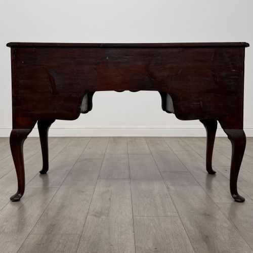 fig 4. A 19th-century Victorian writing table crafted from burr walnut with five drawer fronts, ornate brass drop handles, a shaped central kneehole, and cabriole legs.