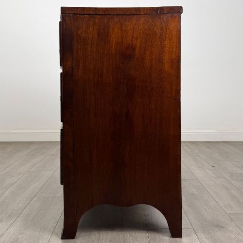 fig 2. An 18th-century Georgian mahogany bow-front chest of drawers featuring two short over two long drawers with brass oval handles and splayed bracket feet.