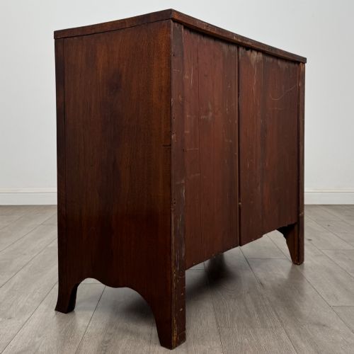 fig 3. An 18th-century Georgian mahogany bow-front chest of drawers featuring two short over two long drawers with brass oval handles and splayed bracket feet.