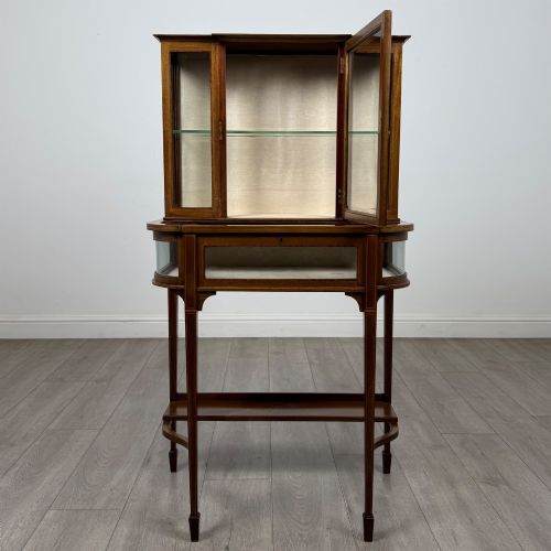 fig 1. An Edwardian mahogany glazed display cabinet featuring tapered legs, line inlay detailing, glass shelves, and a lower undertier shelf.