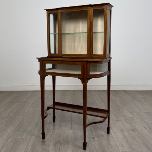 fig 2. An Edwardian mahogany glazed display cabinet featuring tapered legs, line inlay detailing, glass shelves, and a lower undertier shelf.