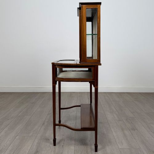 fig 3. An Edwardian mahogany glazed display cabinet featuring tapered legs, line inlay detailing, glass shelves, and a lower undertier shelf.