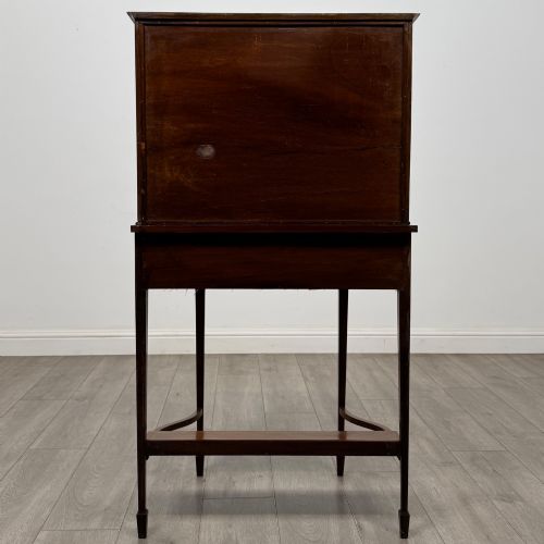 fig 5. An Edwardian mahogany glazed display cabinet featuring tapered legs, line inlay detailing, glass shelves, and a lower undertier shelf.