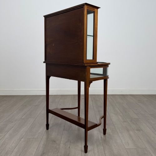 fig 6. An Edwardian mahogany glazed display cabinet featuring tapered legs, line inlay detailing, glass shelves, and a lower undertier shelf.