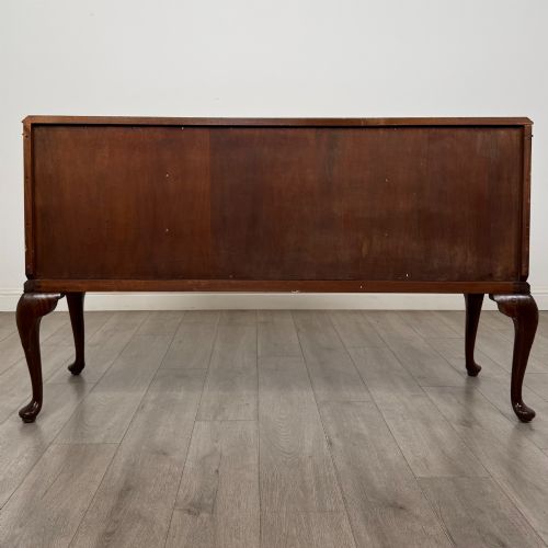 fig 5. An Edwardian burr walnut sideboard featuring three central drawers flanked by two cupboard doors, set on carved cabriole legs.
