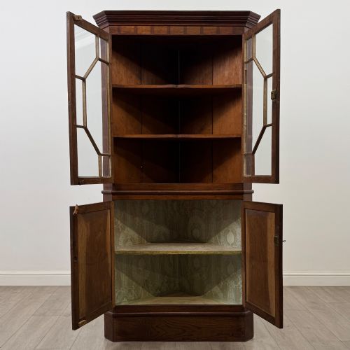 fig 1. An eighteenth century Georgian dark oak standing corner cabinet featuring upper geometric astragal glazed doors and lower panelled cupboard doors.