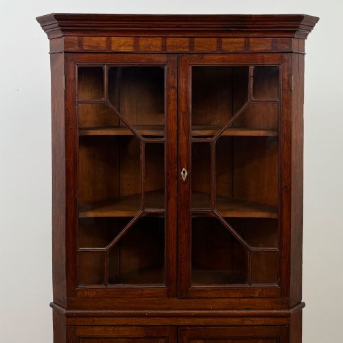 fig 3. An eighteenth century Georgian dark oak standing corner cabinet featuring upper geometric astragal glazed doors and lower panelled cupboard doors.