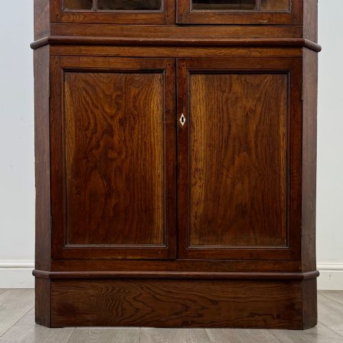 fig 4. An eighteenth century Georgian dark oak standing corner cabinet featuring upper geometric astragal glazed doors and lower panelled cupboard doors.